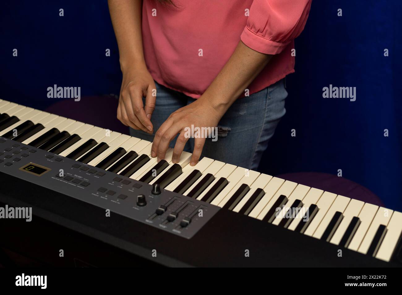 Die lateinamerikanische Lehrerin bringt ihrem Schüler einen Dur-Akkord auf einem Klaviertastatur bei. Das Konzept des Musikunterrichts Stockfoto