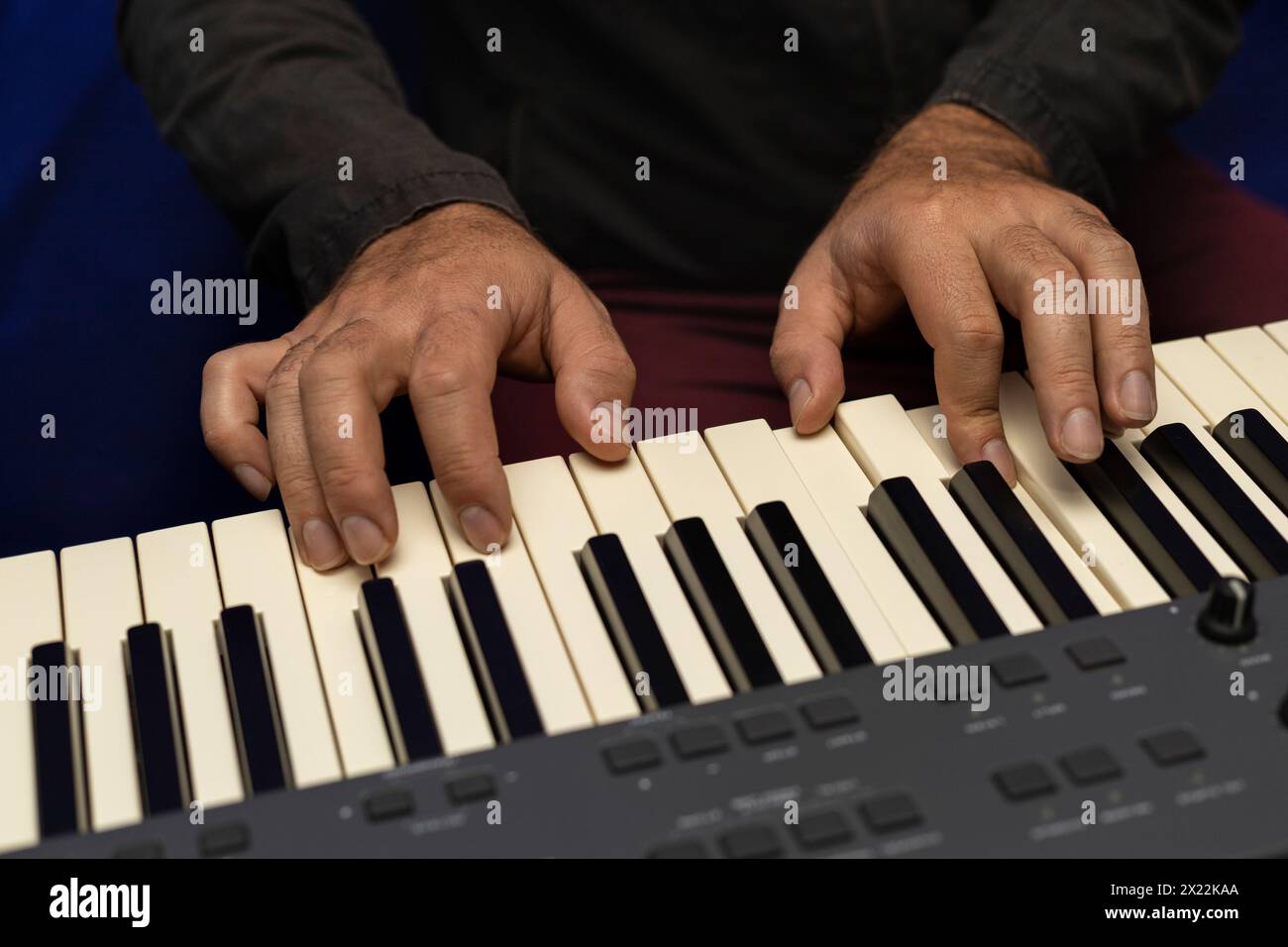 Die Hände des Schülers üben einen Dur-Akkord auf einer Klaviertastatur. Das Konzept des Musikunterrichts Stockfoto
