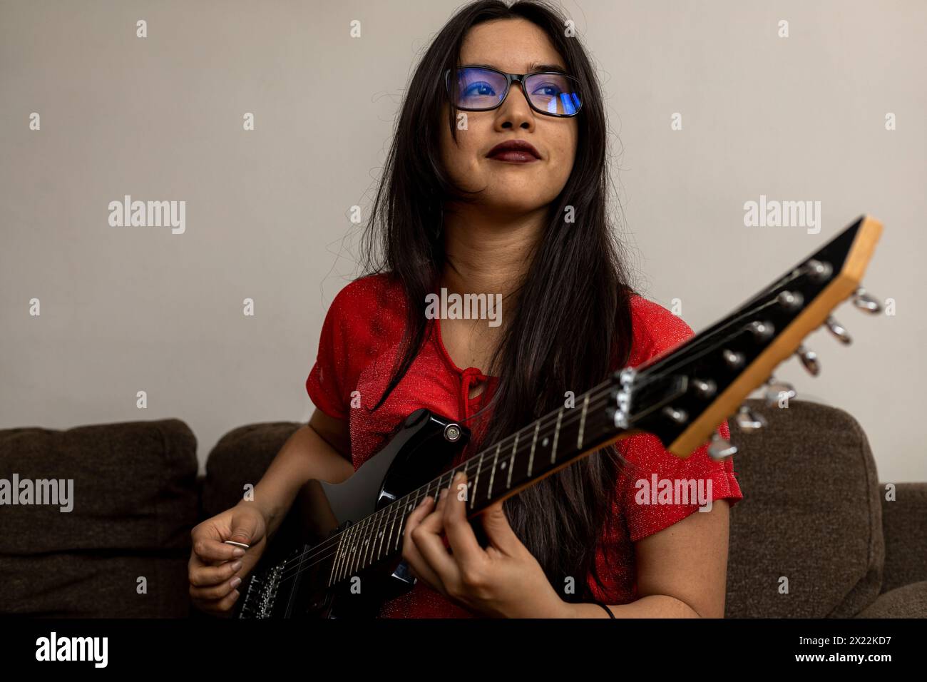 Porträt einer jungen lateinamerikanischen Musikerin mit ihrer E-Gitarre. Musikkonzept Stockfoto