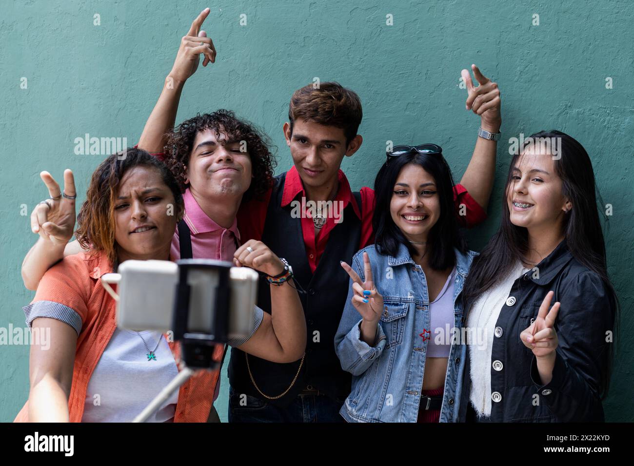 Gruppe junger Latino-Studenten außerhalb der Klasse, die Fotos machen und Spaß haben Stockfoto