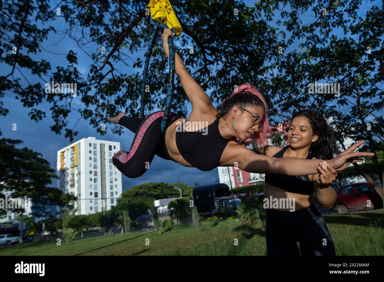 Zwei junge lateinamerikanische Frauen üben auf dem Luftkorb unter freiem Himmel Stockfoto