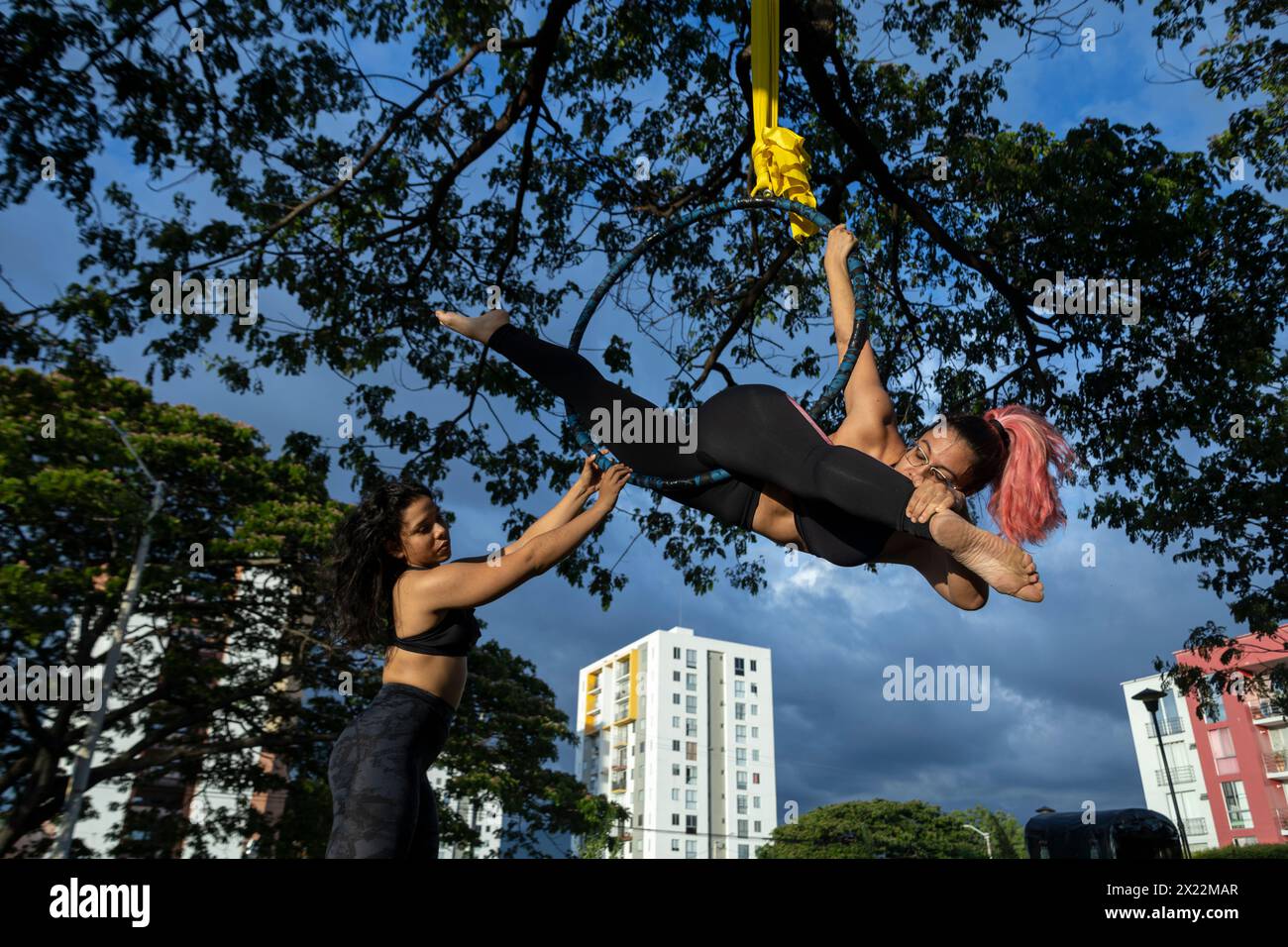 Zwei junge lateinamerikanische Frauen üben auf dem Luftkorb unter freiem Himmel Stockfoto