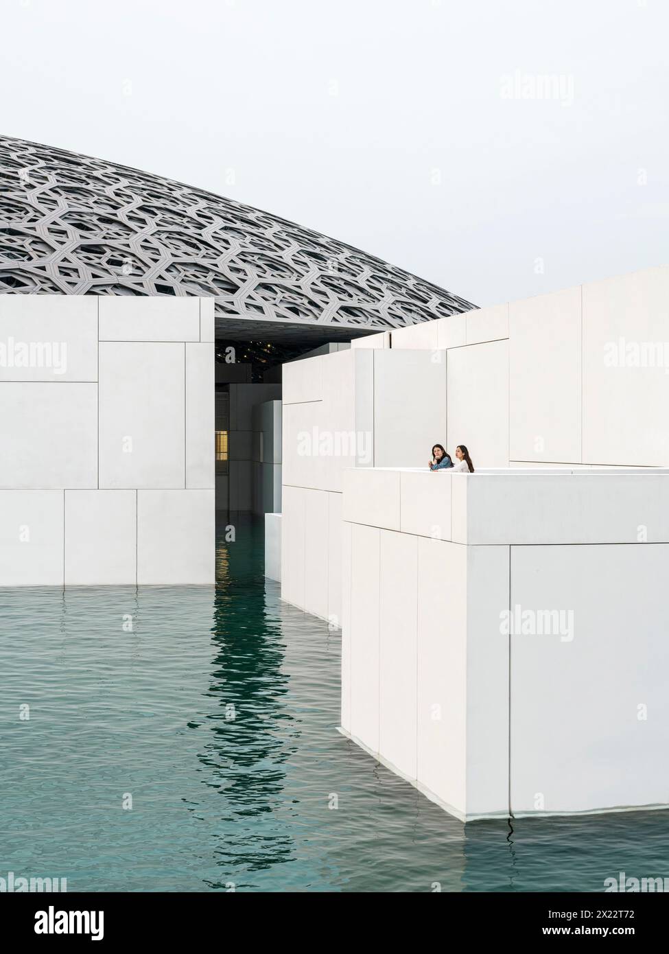 Skulpturale Würfelvolumina im Wasser mit Kuppeldach. Louvre Abu Dhabi, Abu Dhabi, Vereinigte Arabische Emirate. Architekt: Jean Nouvel, 2017. Stockfoto