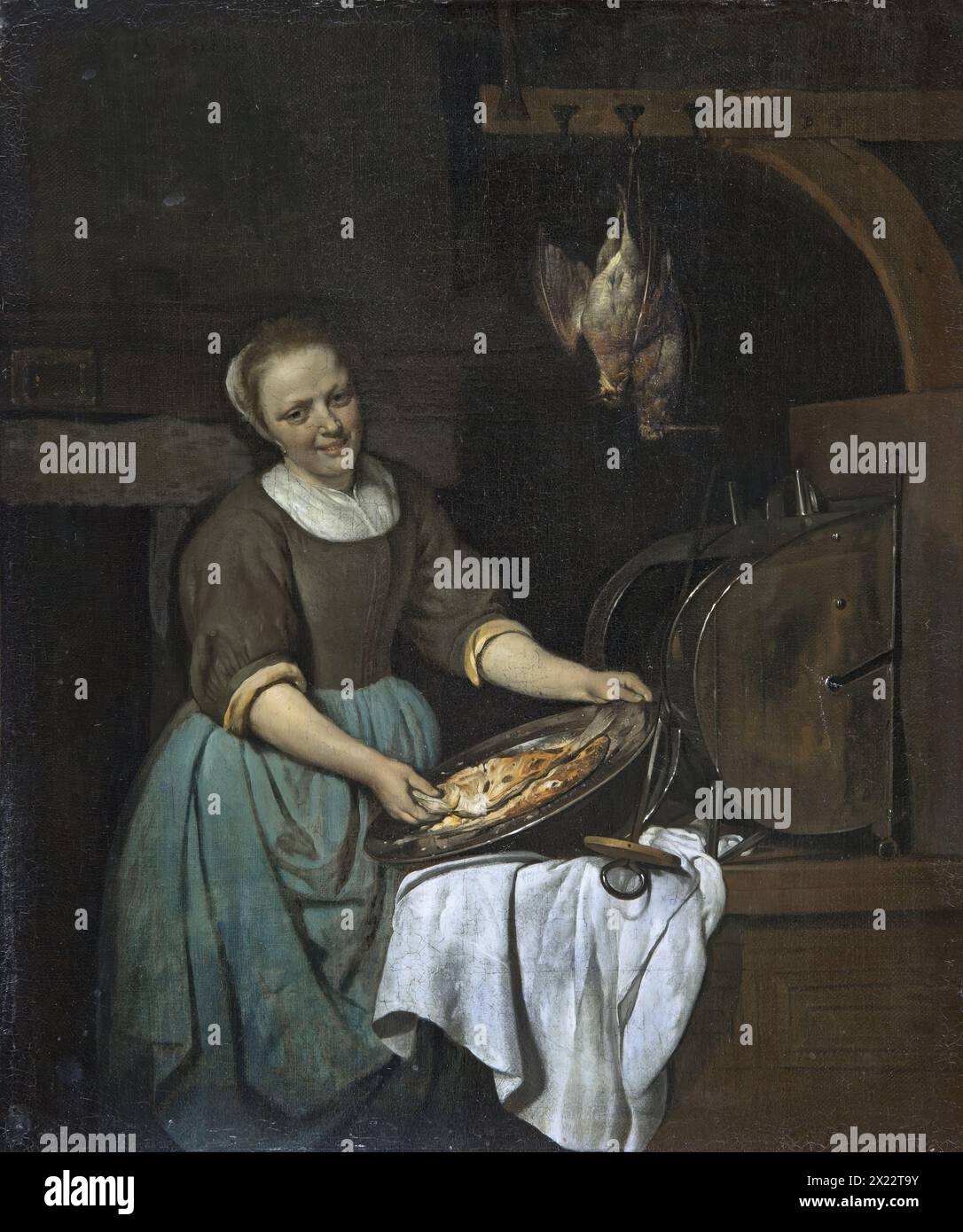 The Cook, 1657. Eine Köchin an ihrem Arbeitsplatz, die uns ein Gericht mit zwei Fischen zeigt. Die Figur hebt sich von einem dunklen Hintergrund ab, in dem wir kaum den Schaft eines hohen Ofens erkennen können, in dem sie kocht. Stockfoto