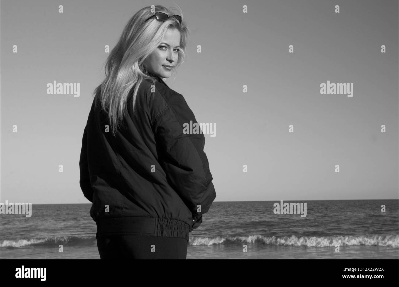 Hübsche junge blonde weiße Frau im Mantel am Hunting Island Beach in South Carolina USA Stockfoto