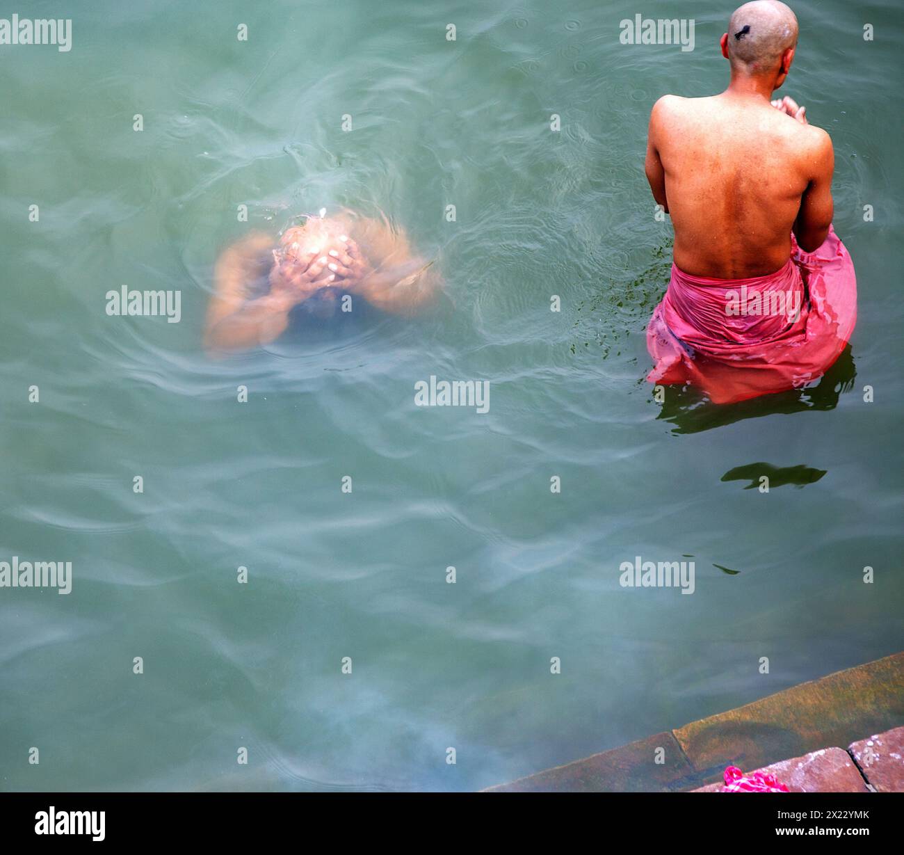Zwei Pilger tauchen in den Ganges in Varanasi, Indien ein. Stockfoto