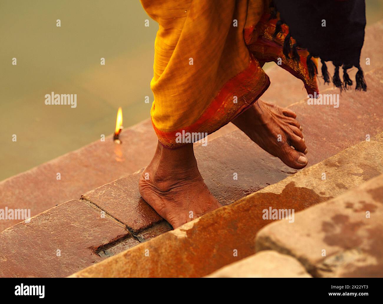 Füße einer Pilgerfrau, die die Stufen eines Ghetts am Ganges in Varanasi, Indien, klettert Stockfoto