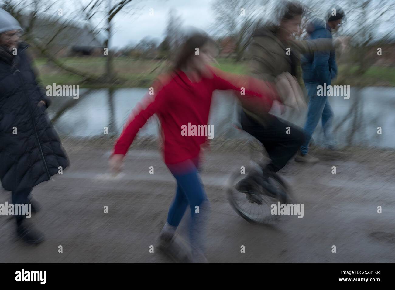 Familienspaziergang, eine junge Frau mit Einrad, Bewegungsunschärfe, Mecklenburg-.Vorpommern, Deutschland Stockfoto