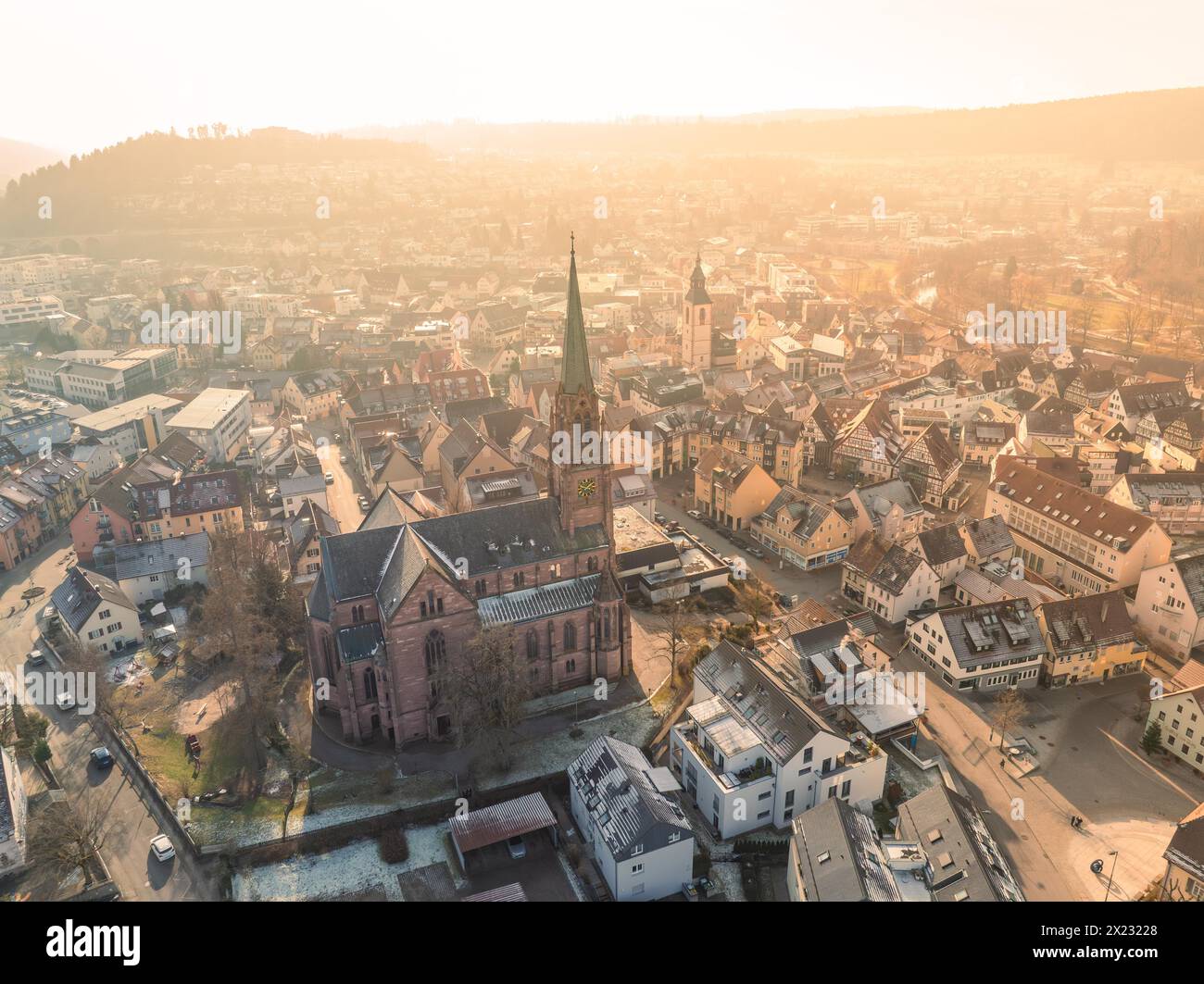 Große Kirche dominiert die Skyline der Stadt im warmen Sonnenuntergang, Sonnenaufgang, Nagold, Schwarzwald, Deutschland Stockfoto