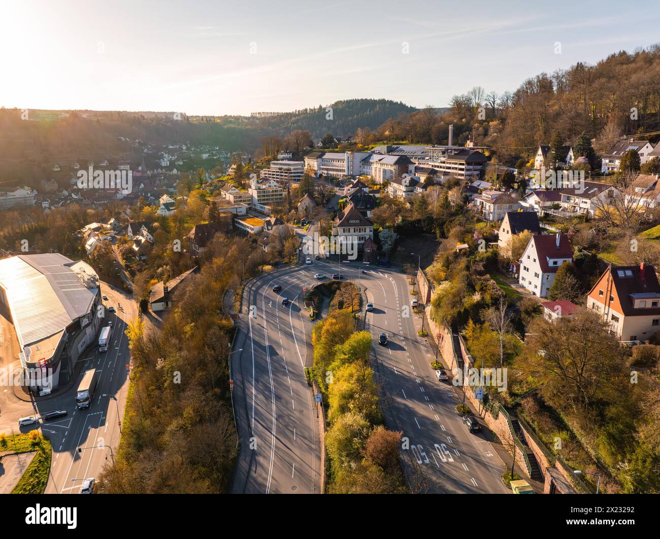 Blick auf eine geschäftige Kreuzung im strahlenden Abendlicht mit Krankenhaus, Calw, Schwarzwald, Deutschland Stockfoto