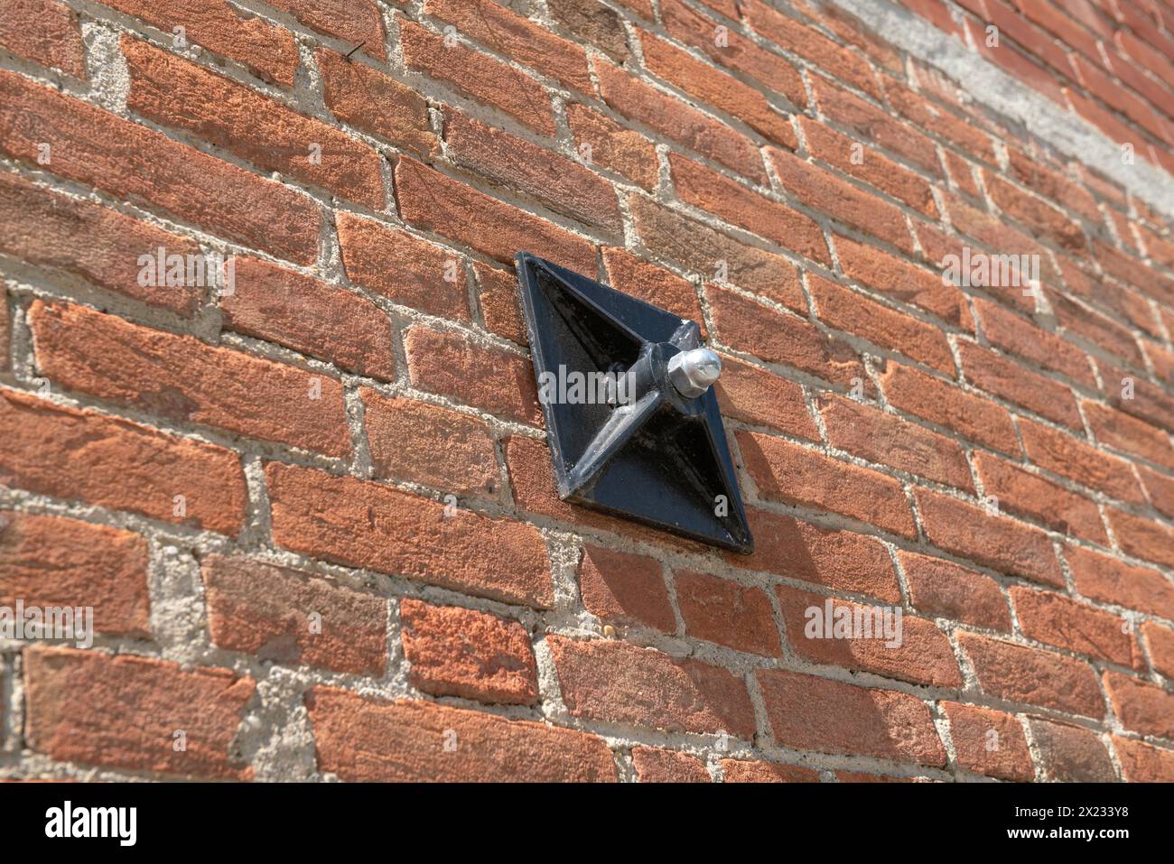 Spurstange an der Wand eines freiliegenden Ziegelgebäudes mit Konstruktionsdetails der Schlüssel, die die internen Spurstangen stützen, Schlüssel - Gegendruckkette für Stockfoto