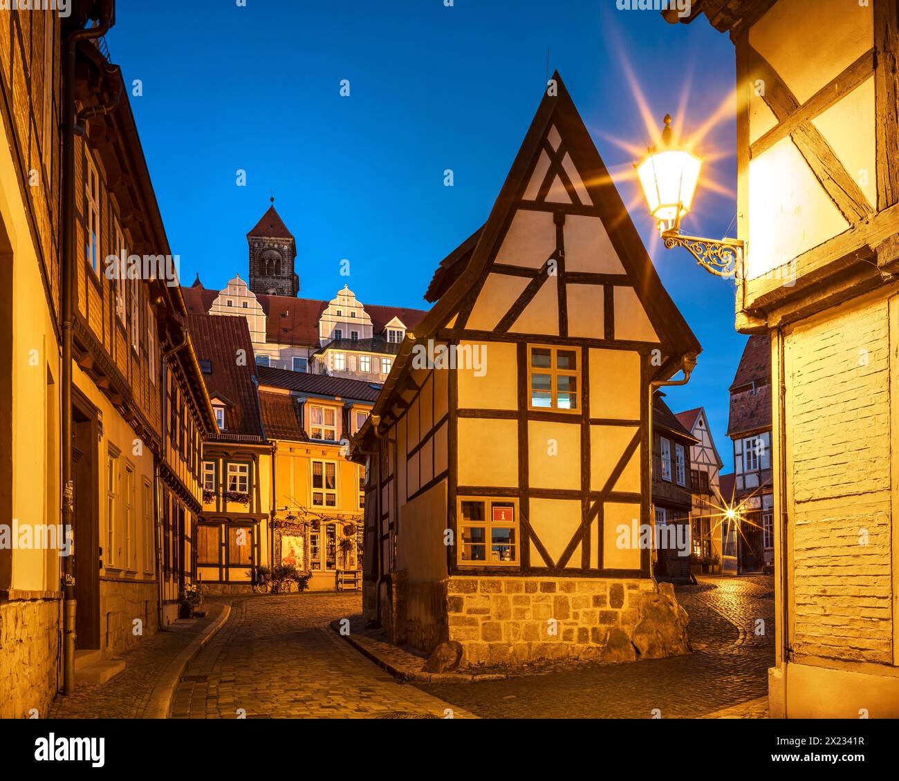 Enge Gasse mit Fachwerkhäusern und Kopfsteinpflaster bei Finkenherd in der historischen Altstadt bei Dämmerung, hinter dem Schlosshügel mit dem Stiftskollegium Stockfoto