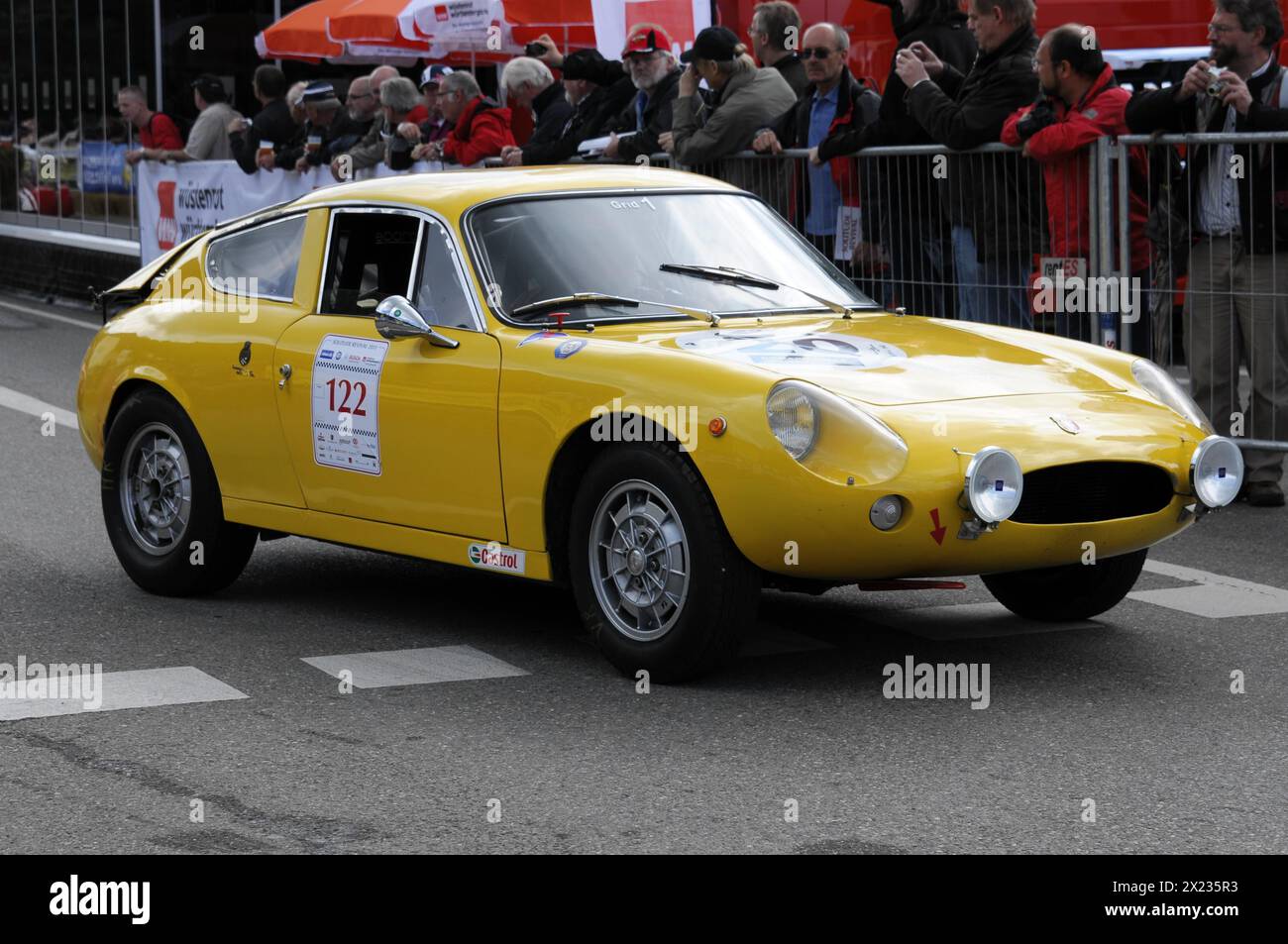 Ein klassischer gelber Sportwagen fährt bei einem Straßenrennen, SOLITUDE REVIVAL 2011, Stuttgart, Baden-Württemberg, Deutschland, vorbei Stockfoto