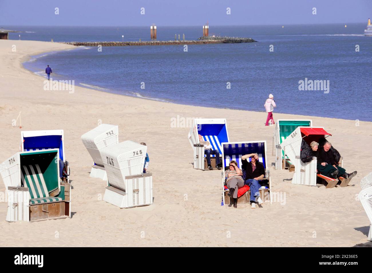 Am Strand bei Hoernum, Sylt, Nordfriesische Insel, Schleswig-Holstein entspannen sich die Menschen in Liegestühlen und spazieren am Sandstrand am Meer entlang Stockfoto