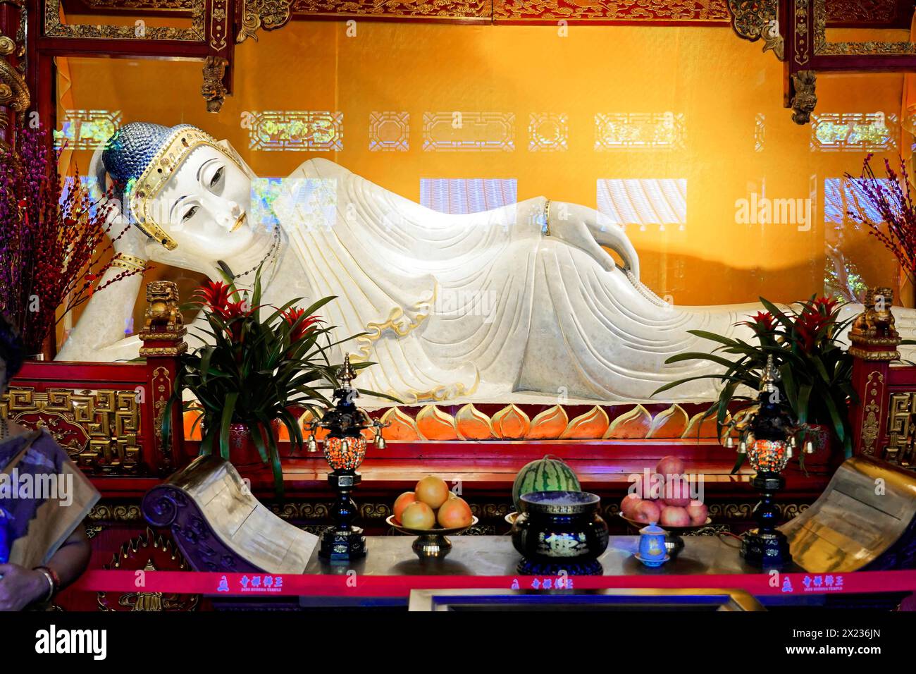 Liegender Jade-Buddha, Jade-Buddha-Tempel, Shanghai, Buddha am Altar umgeben von Opfergaben und Blumendekorationen in friedlicher Stimmung, Shanghai Stockfoto