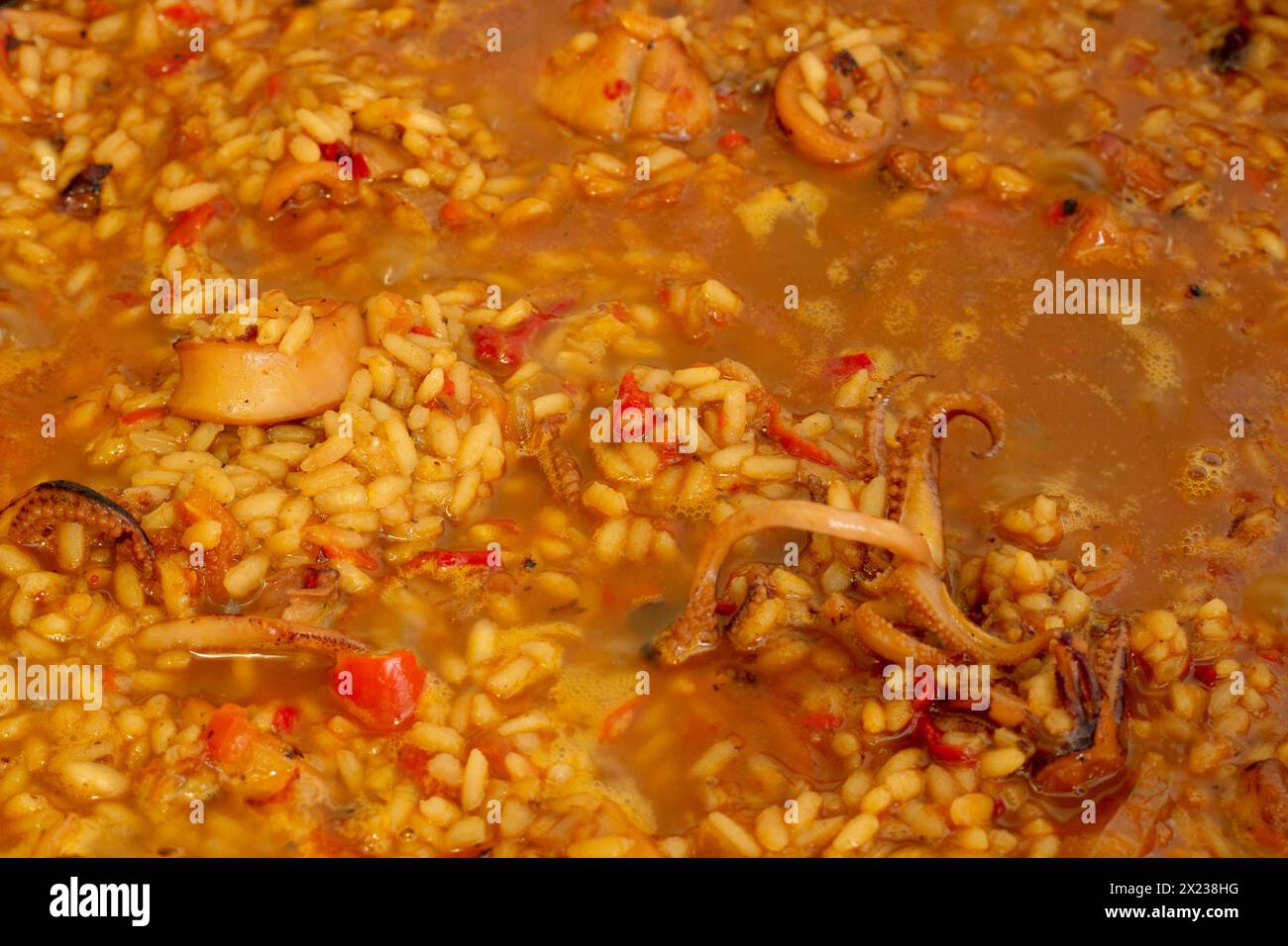 Tauchen Sie ein in die Kunst der spanischen Küche, während die lebendigen Farben und die verführerischen Aromen der Paella während der Zubereitung zum Leben erweckt werden Stockfoto