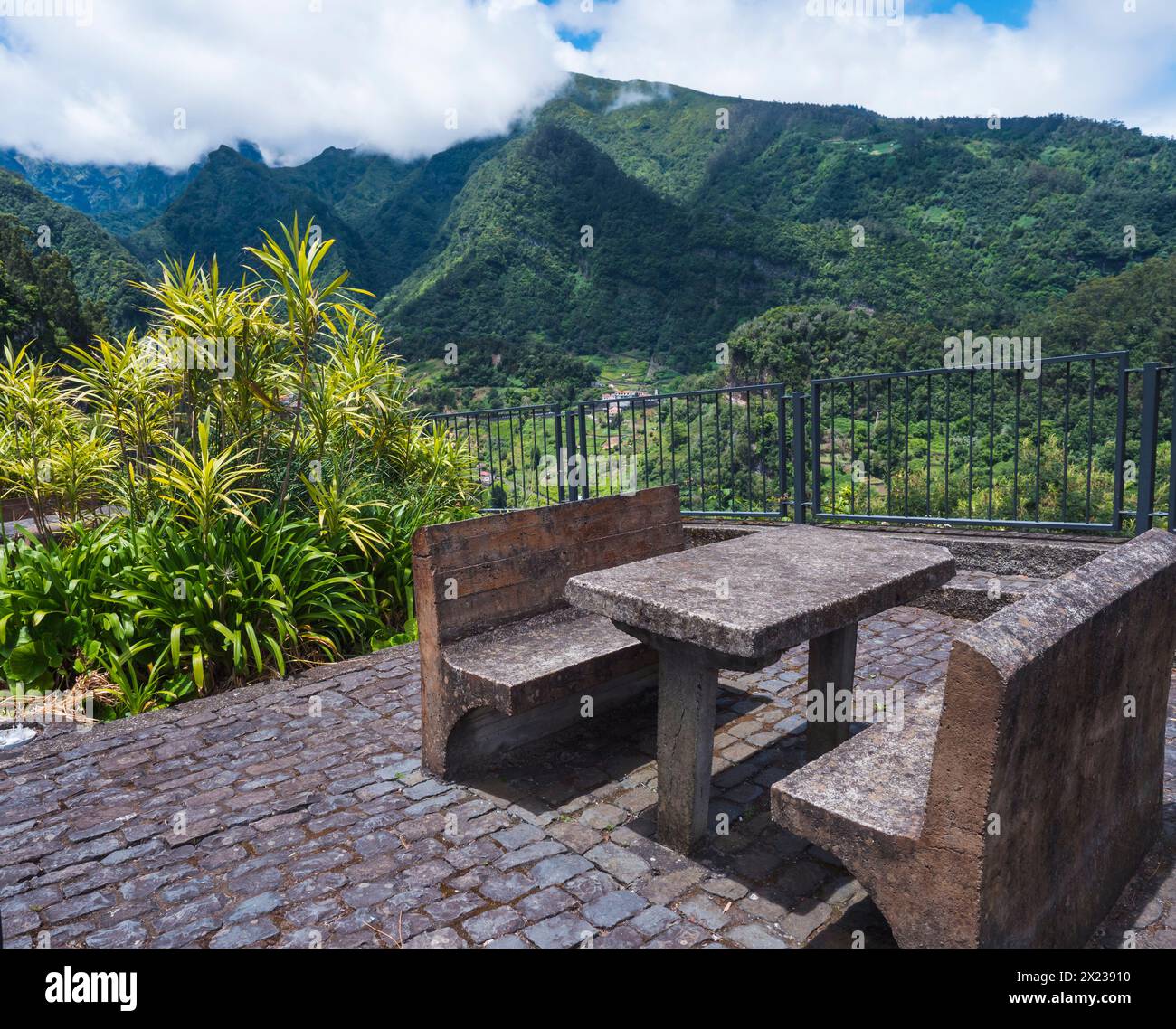 Betonbank und Tisch mit wunderschönem Blick auf die grünen Hügel und das Tal vom Ruheplatz aus, Aussichtspunkt bei Sao Roque do Faial Santana, Insel Madeira, n Stockfoto