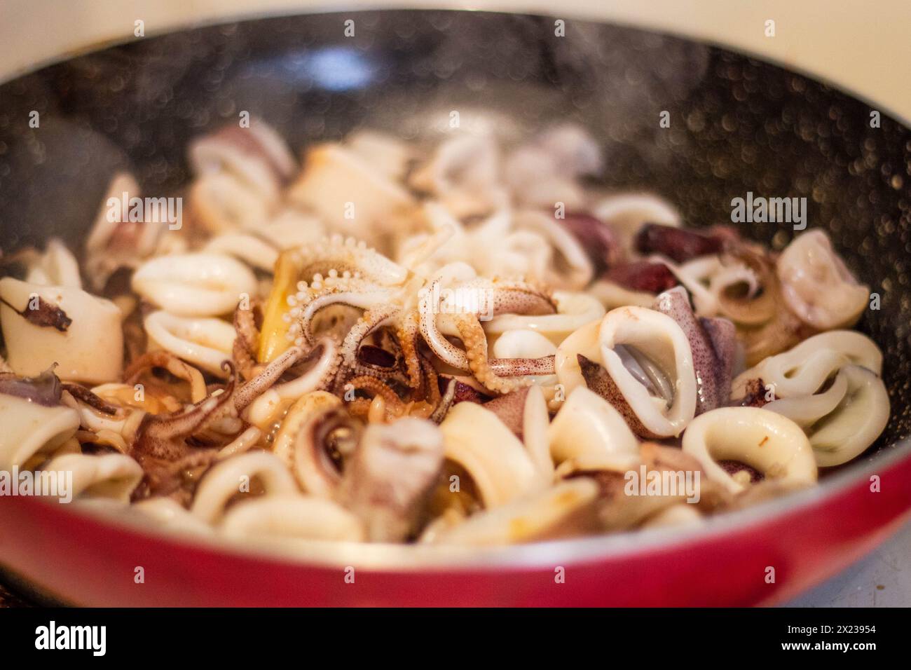 Genießen Sie das Bratschen und Aroma frisch gekochter Calamari in der Pfanne. Erleben Sie die kulinarische Kunst und den Genuss der mediterranen Küche Stockfoto