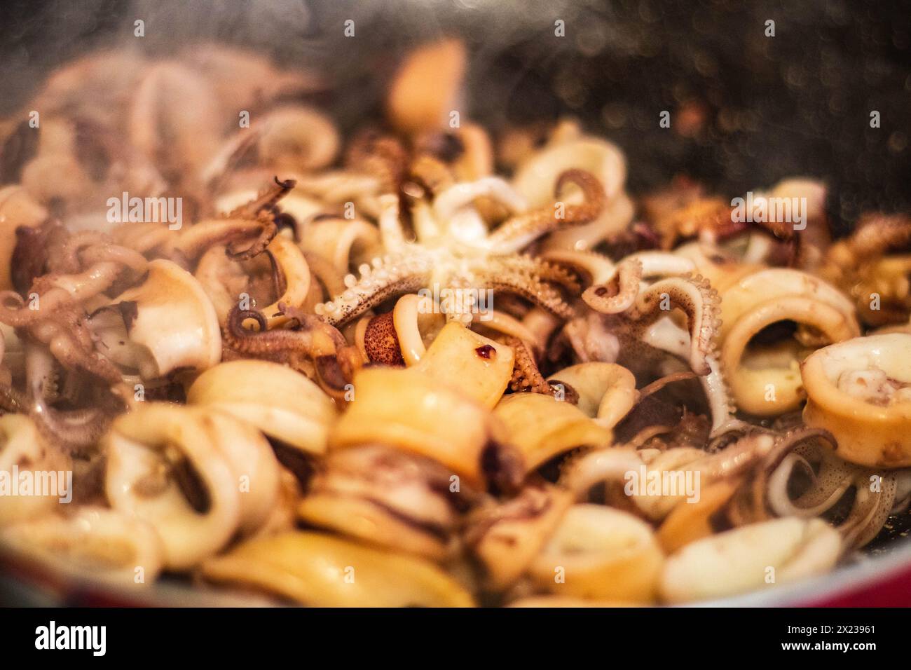 Genießen Sie das Bratschen und Aroma frisch gekochter Calamari in der Pfanne. Erleben Sie die kulinarische Kunst und den Genuss der mediterranen Küche Stockfoto