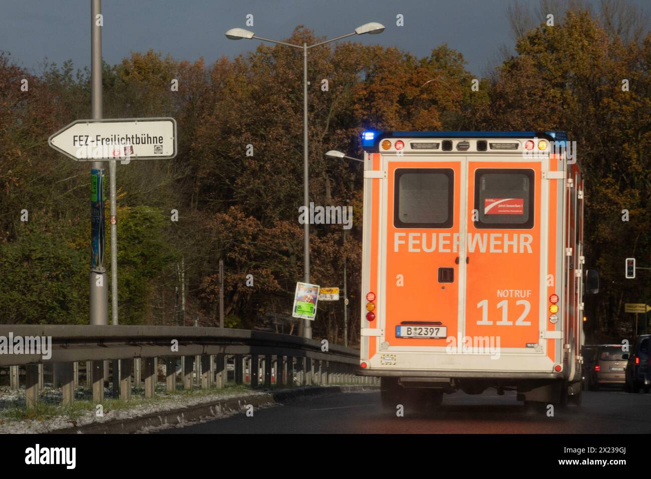 25.11.2023, Berlin, DE - Rettungswagen der Berliner Feuerwehr auf Einsatzfahrt. 112, Alltag, Ambulanz, Arzt, aussen, Aussenaufnahme, Berlin, Blaulicht, Blaulichtfahrt, deutsch, Deutschland, Doppelseite, Einsatz, Erste Hilfe, Europa, europaeisch, Fahrzeug, Feuerwehr, FEZ-Freilichtbühne, Gesellschaft, Helfer, Hilfe, Jahreszeit, Job, Krankenwagen, Not, Notarzt, Notdienst, Noteinsatz, Notfall, Nothelfer, Nothilfe, Notruf, Personenschaden, PKW, QF, Querformat, Retter, Rettung, Rettungsdienst, Rettungsdienstwagen, Rettungseinsatz, Rettungsfahrt, Rettungswagen, Rettungswesen, RTW, Rueckansicht, Sta Stockfoto