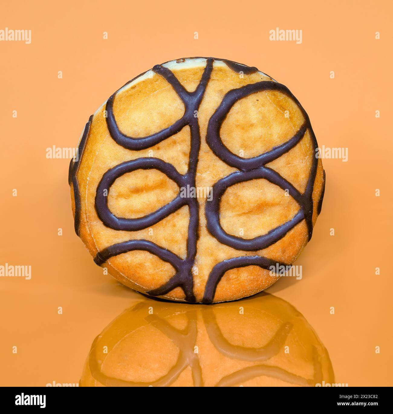 Toffee gefüllter Donut stehend auf einem Toffee farbigen Hintergrund Stockfoto