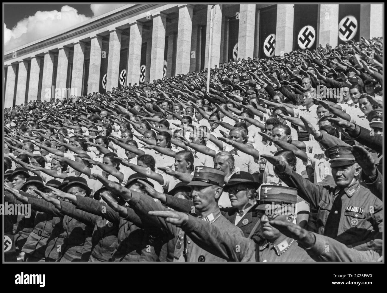 1930er Jahre: Nürnberger Nazi-Deutschland-Kundgebung mit Mitgliedern der paramilitärischen Armee der Sturmbleitung und Mädchen der BDM. BUND DEUTSCHER MADEL., der Mädchenjugendflügel der NSDAP. Alle geben Adolf Hitler den Nazi-Heil-Hitler-Gruß. Nürnberg Nürnberg Nazideutschland Stockfoto