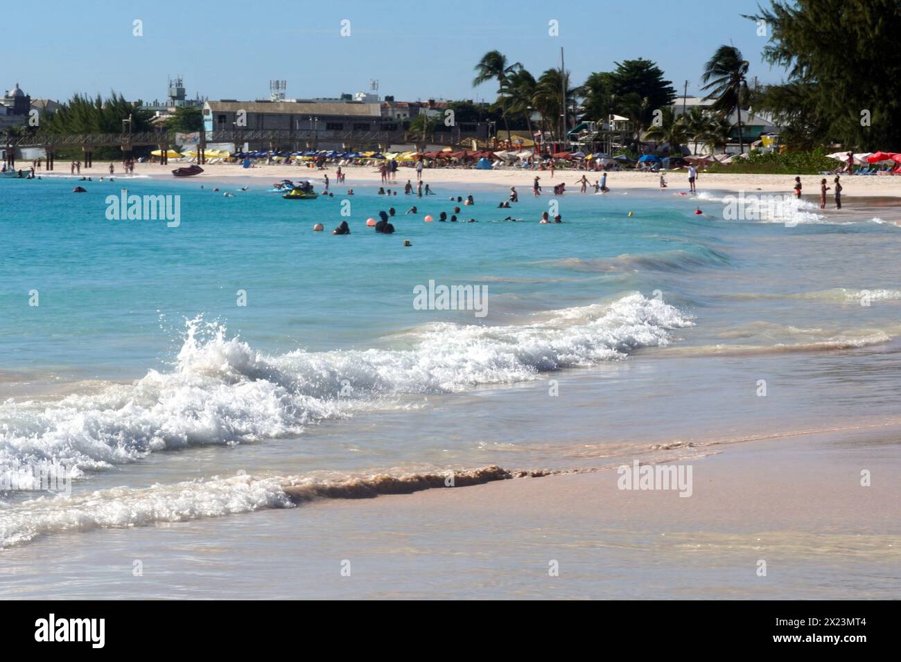 Strände mit Sonnenschirmen und azurblaues Meer mit Wellen auf der Karibikinsel Barbados in der Nähe von Bridgetown. Stockfoto