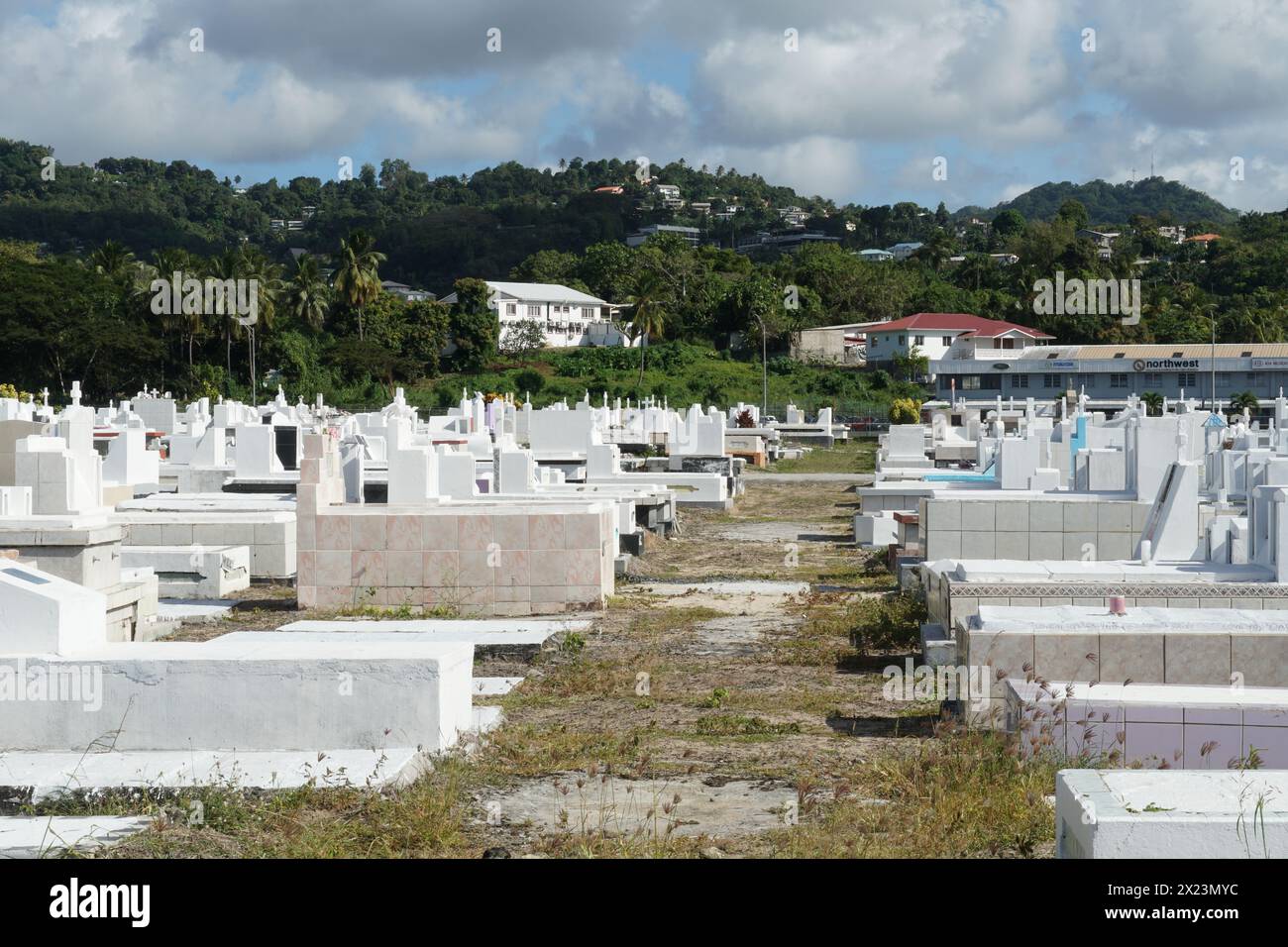 Pfad zwischen weißen Gräbern und Grabsteinen auf einem Friedhof in der Nähe des Strandes in Castries, Saint Lucia. Stockfoto