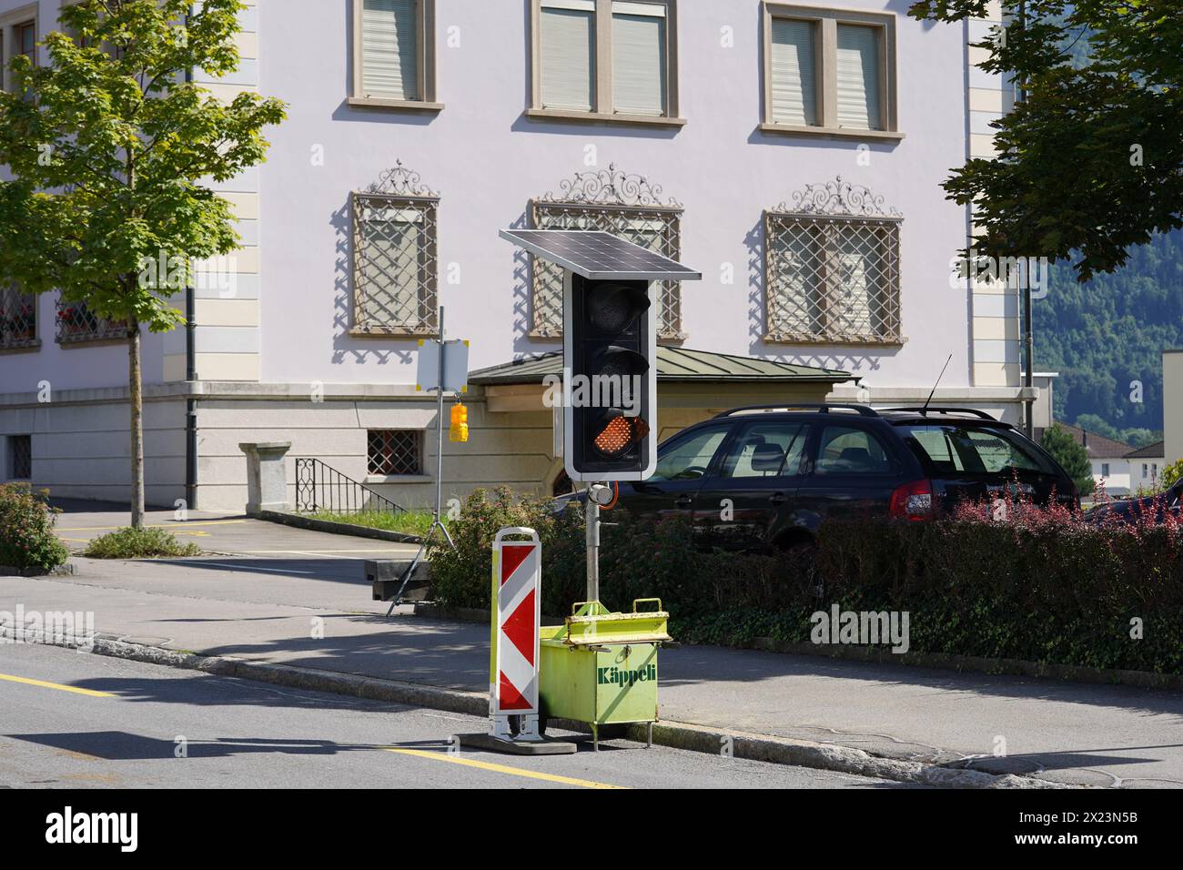 Tragbare Bremsleuchte mit Solarpaneelen an der Straße, die den Verkehr während der Bauarbeiten in Schwyz, Schweiz, lenken. Stockfoto