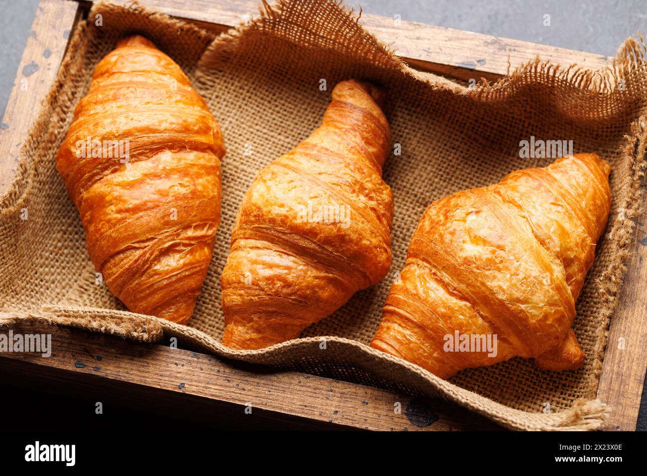 Frische Croissants in Holzkiste Stockfoto