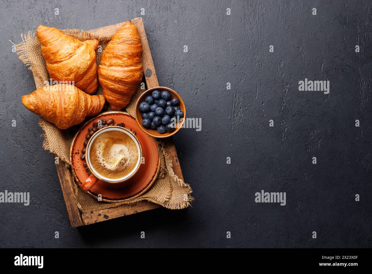 Cappuccino-Kaffee und frische Croissants auf Steintisch. Flache Ladefläche mit Kopierraum Stockfoto