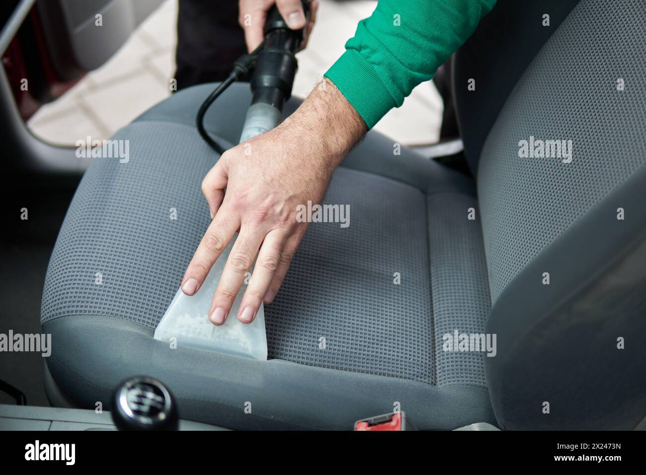 Details zur Fahrzeugreinigung – männlich mit professioneller chemischer Dampfreinigung für schmutzige Innensitze im Auto mit Extraktionsmethode Stockfoto