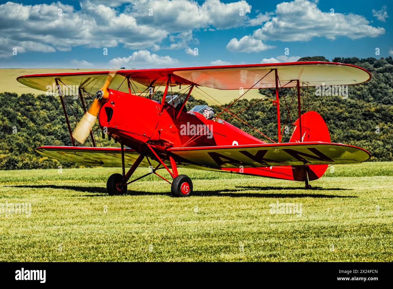 Ein helles rot 1930er Jahre de Havilland Tiger Moth auf der Graspiste Stockfoto