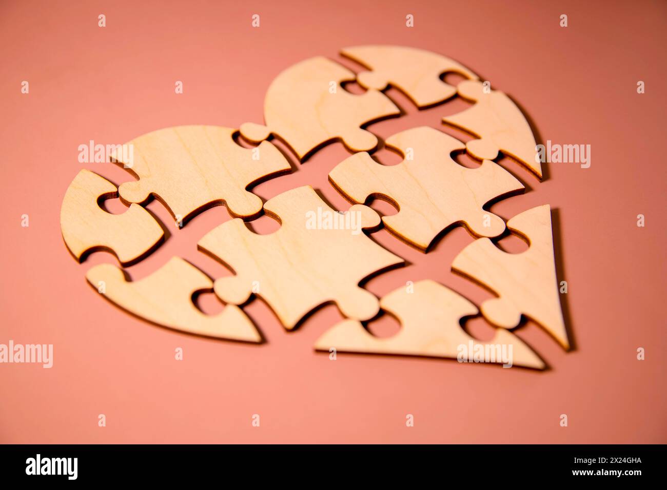 Heart-shaped Puzzle auf farbigen Hintergrund. Puzzle Herz auf Holz- Hintergrund. Ein fehlendes Stück des Herzens Puzzle. Herz Puzzle. Puz Stockfoto