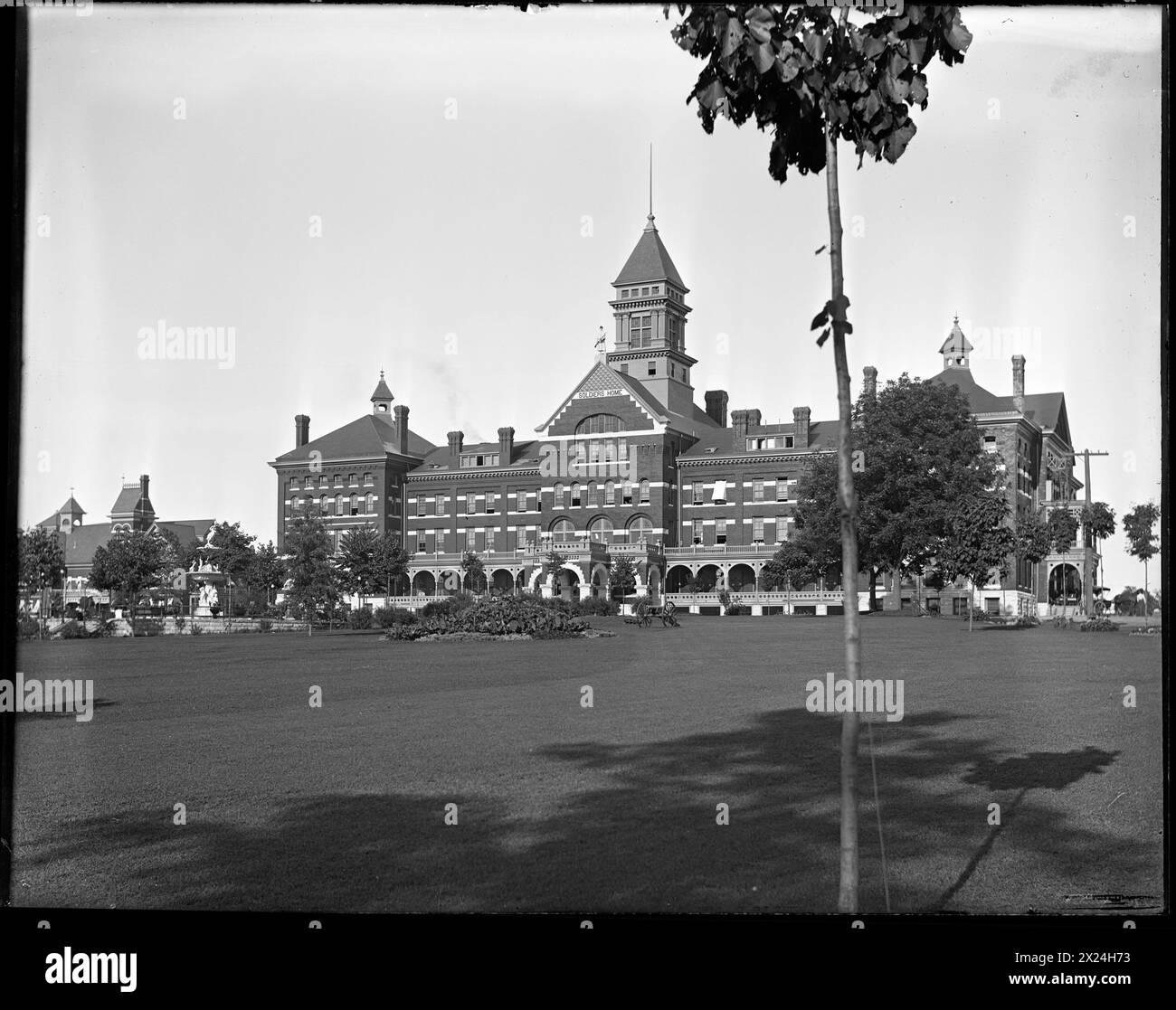 Vintage-Foto. Michigan Soldiers' Home, Grand Rapids, Michigan, 6. August 1901. Historisches viktorianisches Architekturgebäude mit zentralem Uhrenturm, Blick von einem Park mit Bäumen Stockfoto