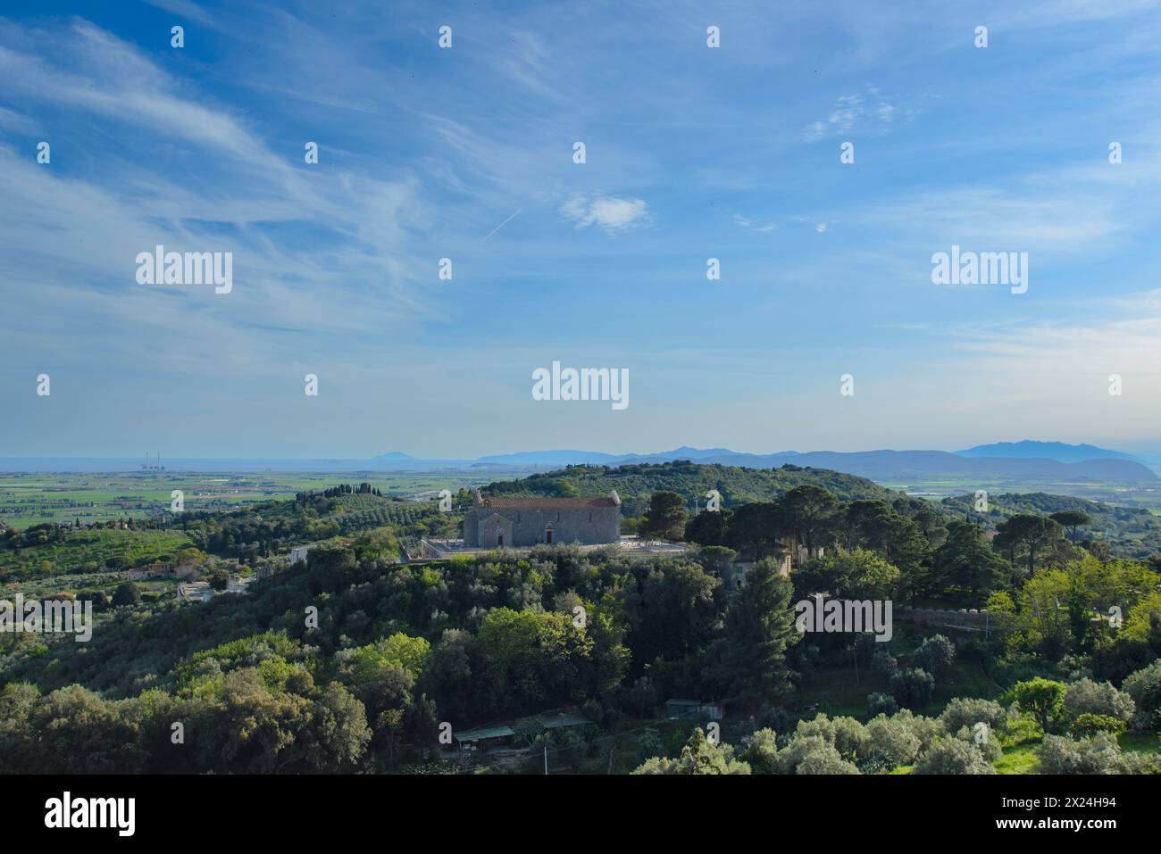 Aus der Vogelperspektive auf das Val di Cornia mit der Pieve di San Giovanni, Hügel, mediterraner Busch und Meer, Campiglia Marittima, Toskana, Italien Stockfoto