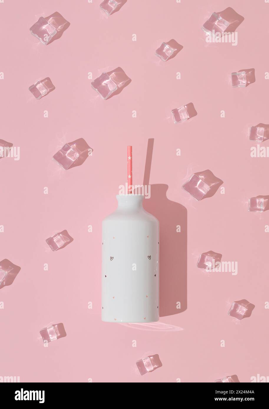 Eiswürfelmuster mit weißer Flasche auf pastellrosa Hintergrund. Minimales Sommergetränk-Konzept. Kreative, trendige Sommerparty-Idee. Flache Lagen. Stockfoto