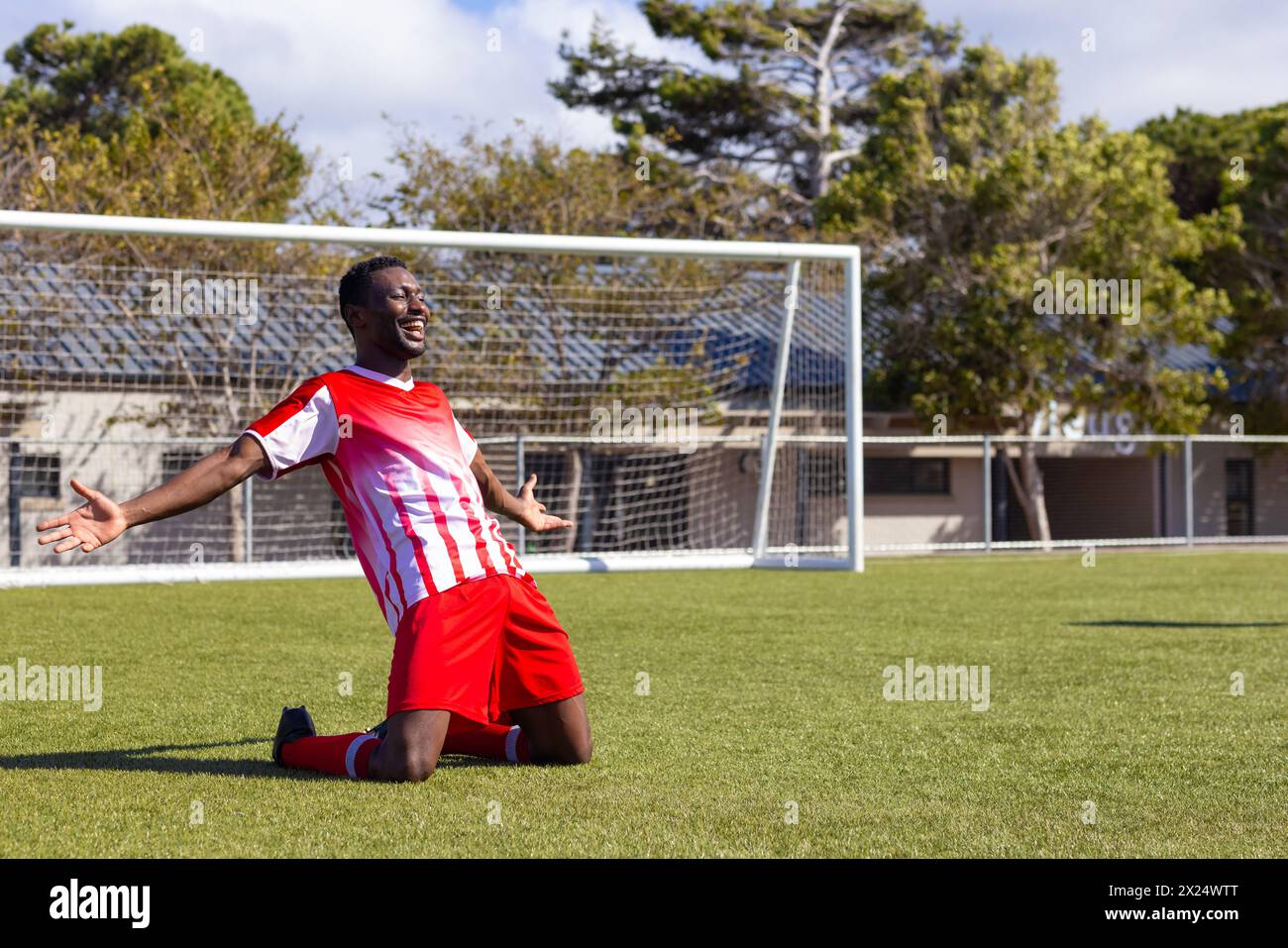 Afroamerikanischer junger männlicher Athlet, der auf dem Fußballfeld im Freien feiert Stockfoto