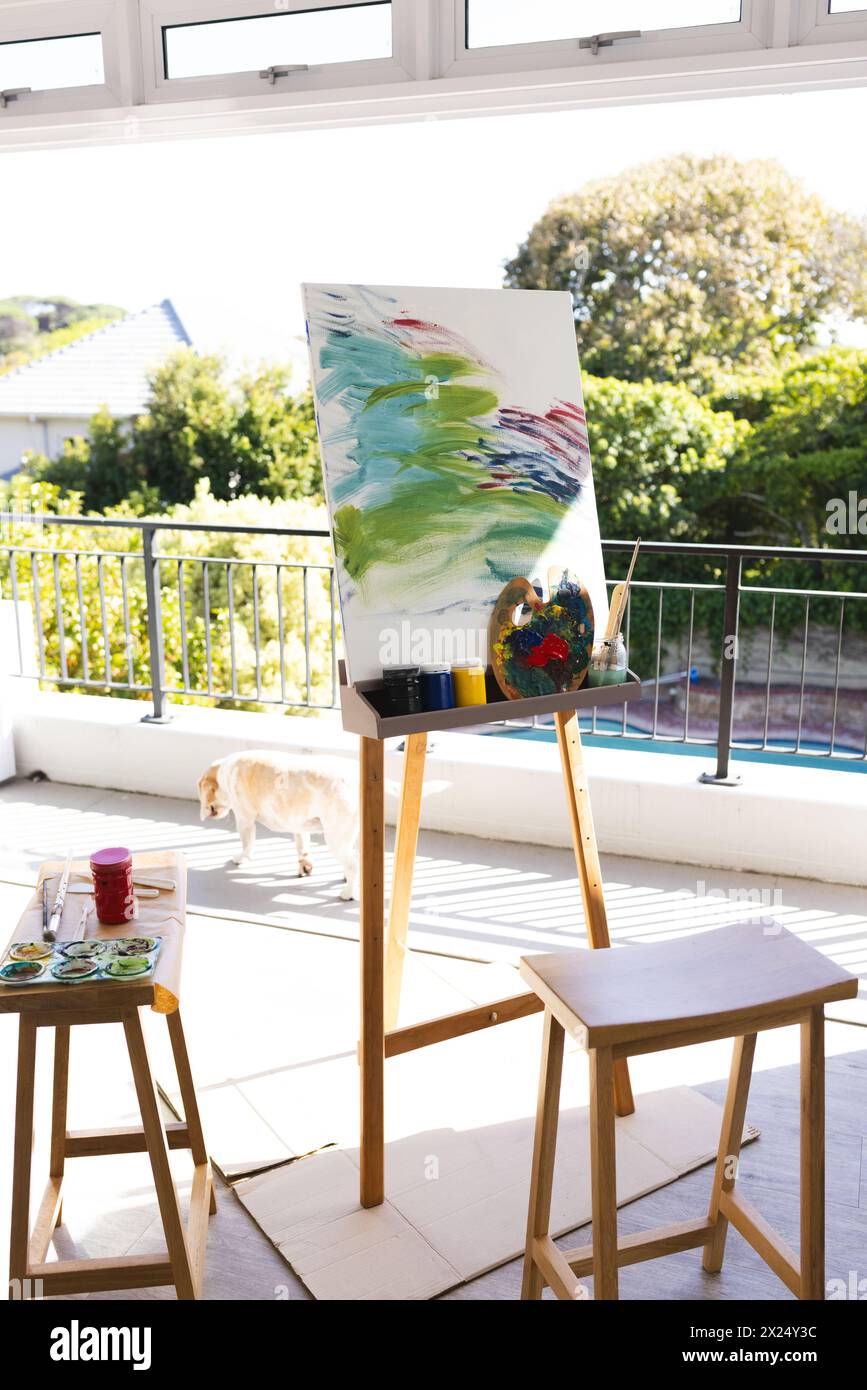 Farbenfrohe Kunstwerke auf Leinwand zu Hause in einem hellen Raum mit einem Hund, der vorbeigeht Stockfoto