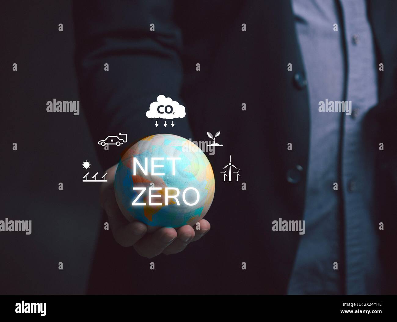 Netto-Null-Emission – Konzept der CO2-Neutralität. Ein Mann hält eine Globus-Ikone und hat eine Ikone, die ungefähr um die Netto-Null geht. Natur Сonservation, Ökologie, Soziale Angelegenheiten Stockfoto