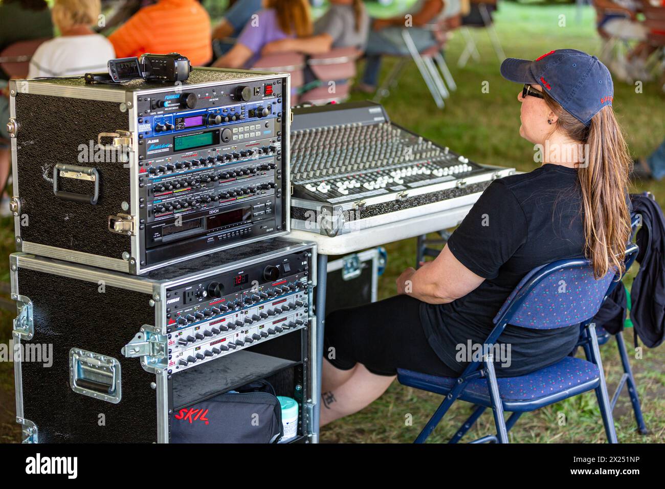 Eine Tontechnikerin sitzt bei einem Konzert im Freien in Fort Wayne, Indiana, USA, am Soundboard. Stockfoto