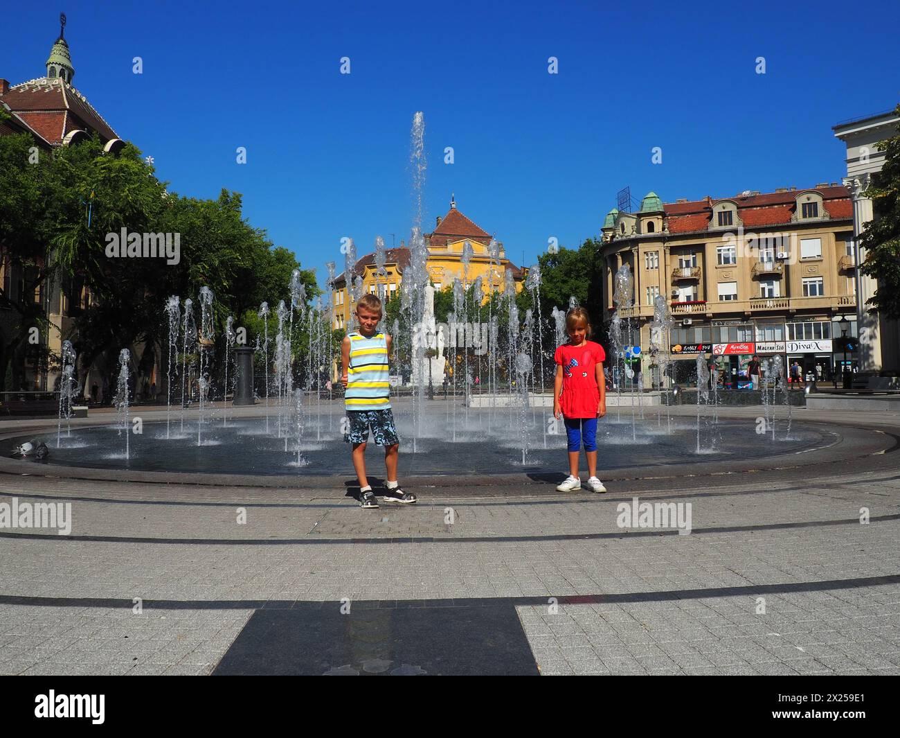 Subotica, Serbien, 12. September 2021. Brunnen auf dem Platz von Subotica in der Nähe des Rathauses. Schulkinder, Junge und Mädchen, Bruder und Schwester sind stan Stockfoto