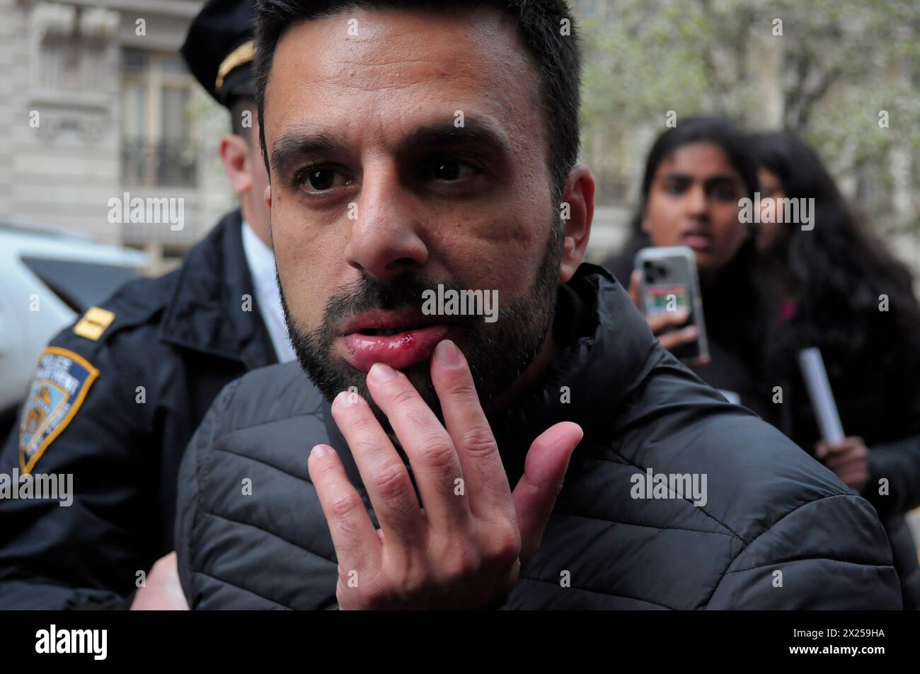 Ein pro-israelischer Demonstrant berührt seine blutige Lippe nach Zusammenstößen bei einer pro-palästinensischen Kundgebung vor der Columbia University. Pro-palästinensische Demonstranten versammelten sich innerhalb und außerhalb der Columbia University in Manhattan, New York City, und verurteilten die Militäroperationen der israelischen Streitkräfte in Gaza. Seit Mittwoch haben Studenten und pro-palästinensische Aktivisten innerhalb der Universität einen Sit-in-Protest auf dem Rasen abgehalten und ein Lager gebildet. Das New York City Police Department verhaftete am Donnerstag mehr als 100 Aktivisten aus dem Campus. Seit Beginn des Krieges am 7. Oktober 2023, Gaza's Health min Stockfoto