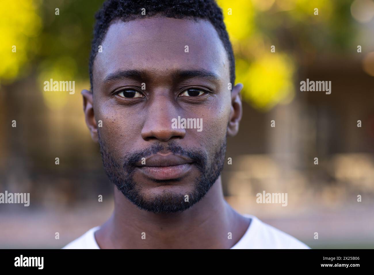 Afroamerikanischer junger männlicher Athlet, der auf einem Feld steht, direkt in die Kamera blickt, Kopierraum Stockfoto