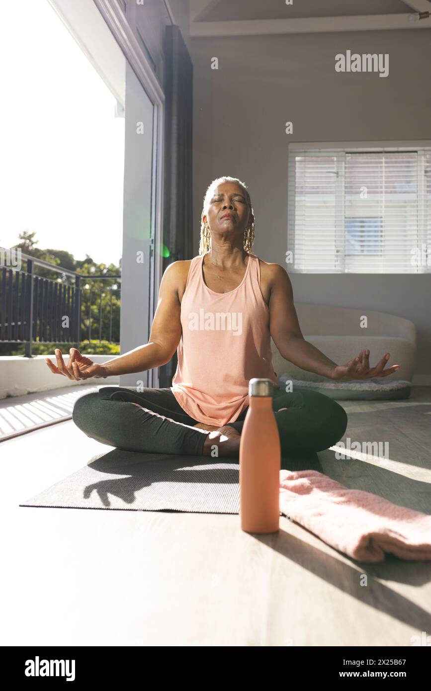 Afroamerikanerin, die zu Hause Yoga auf der Matte praktiziert Stockfoto