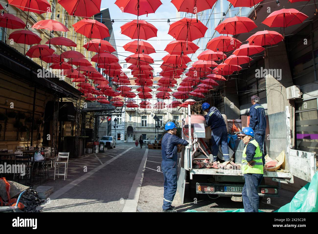 Belgrad, Serbien, März 2019 - Bauarbeiter auf dem Job unter roten Schirme über dem Cara Lazara Straße in der Fußgänger-Zone der Stadt ausgesetzt Stockfoto