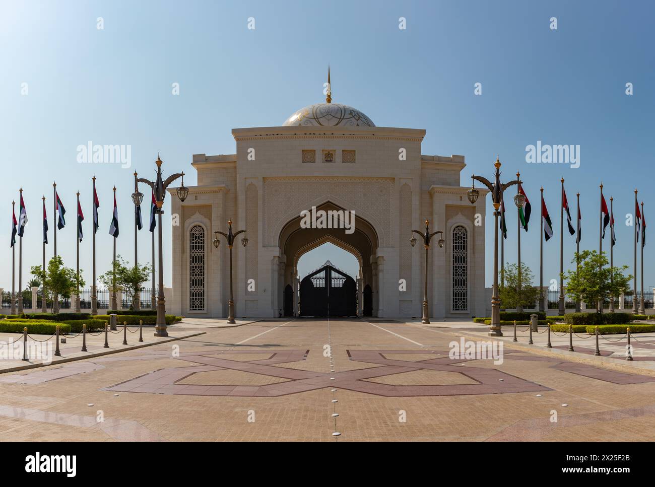 Ein Bild des am weitesten entfernten Qasr Al Watan-Eingangs mit mehreren Flaggen der Vereinigten Arabischen Emirate. Stockfoto
