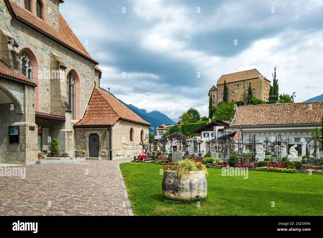 Malerischer Kirchhof mit Blick auf Schloss Schenna, auf dem Kirchenhügel Schenna oberhalb von Meran, im Burggrafengebiet, Südtirol, Italien. Stockfoto