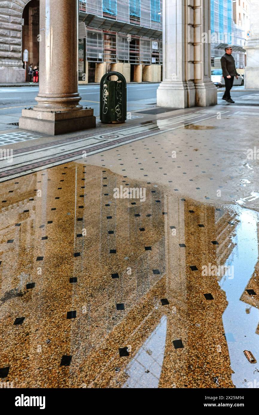 Genua, Italien - 3. Dezember: Galerie der Bögen mit Säulen im Gebäude der Stadtverwaltung auf dem Ferrari-Platz in wunderschönem Sonnenuntergang mit Reflexion im Wasser. Palazzo della Regione Liguria in Genua, Ligurien, Italien Stockfoto