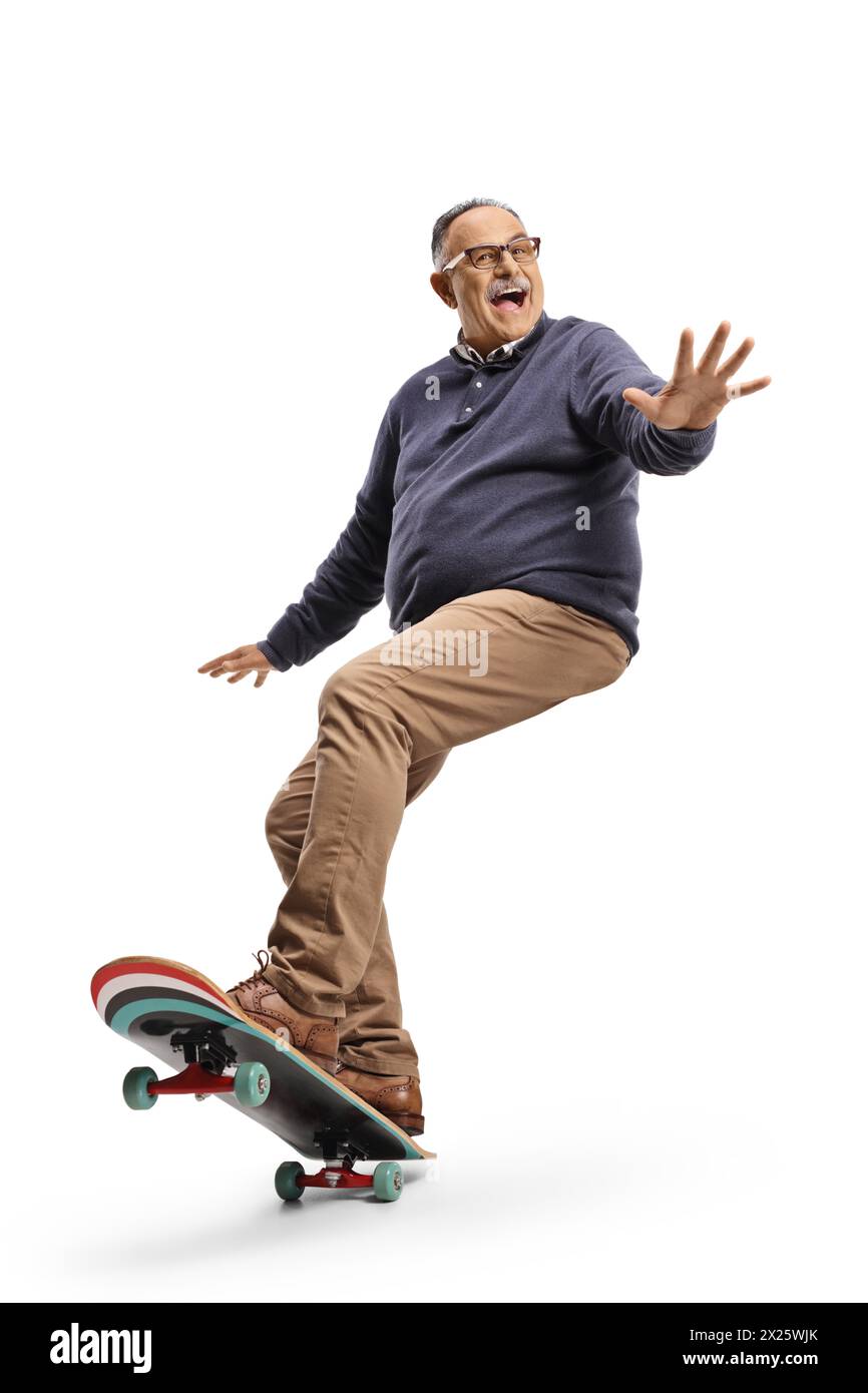 Glücklicher reifer Mann, der auf einem Skateboard fährt und isoliert auf weißem Hintergrund winkt Stockfoto